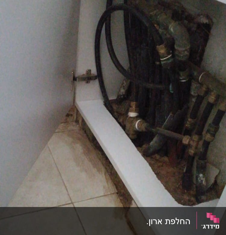 ארון פתוח עם צינורות ומחברים מתכתיים